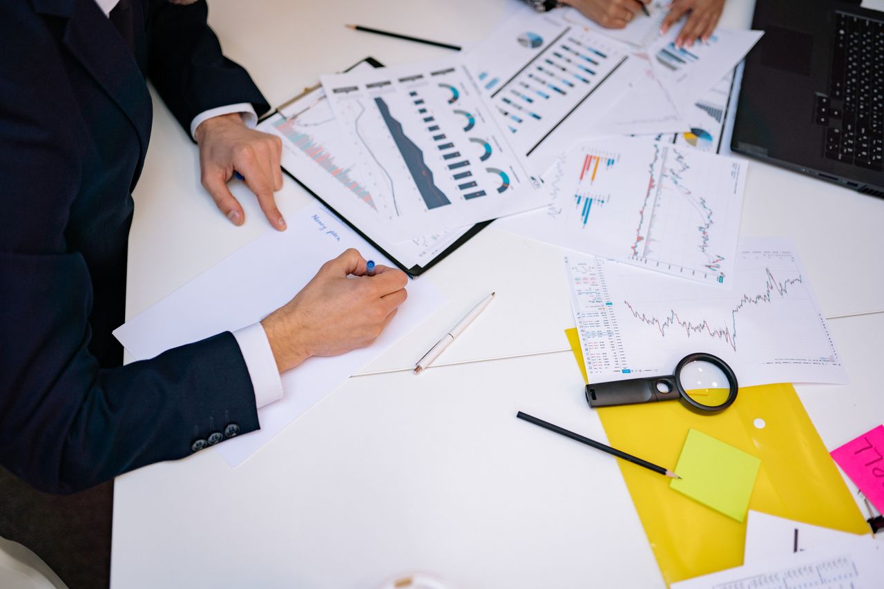 Close-up of a desk cluttered with financial charts, graphs, and reports, perfect for business and finance themes.